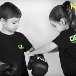 young girl helping young boy to put on gloves