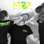 young children play fighting with instructor with logo